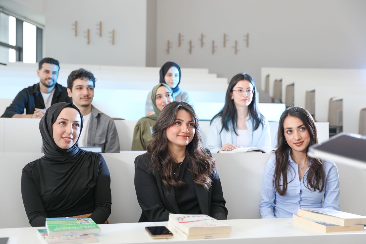 project-02-d Group of diverse students in a university classroom during a lecture, engaged and attentive.