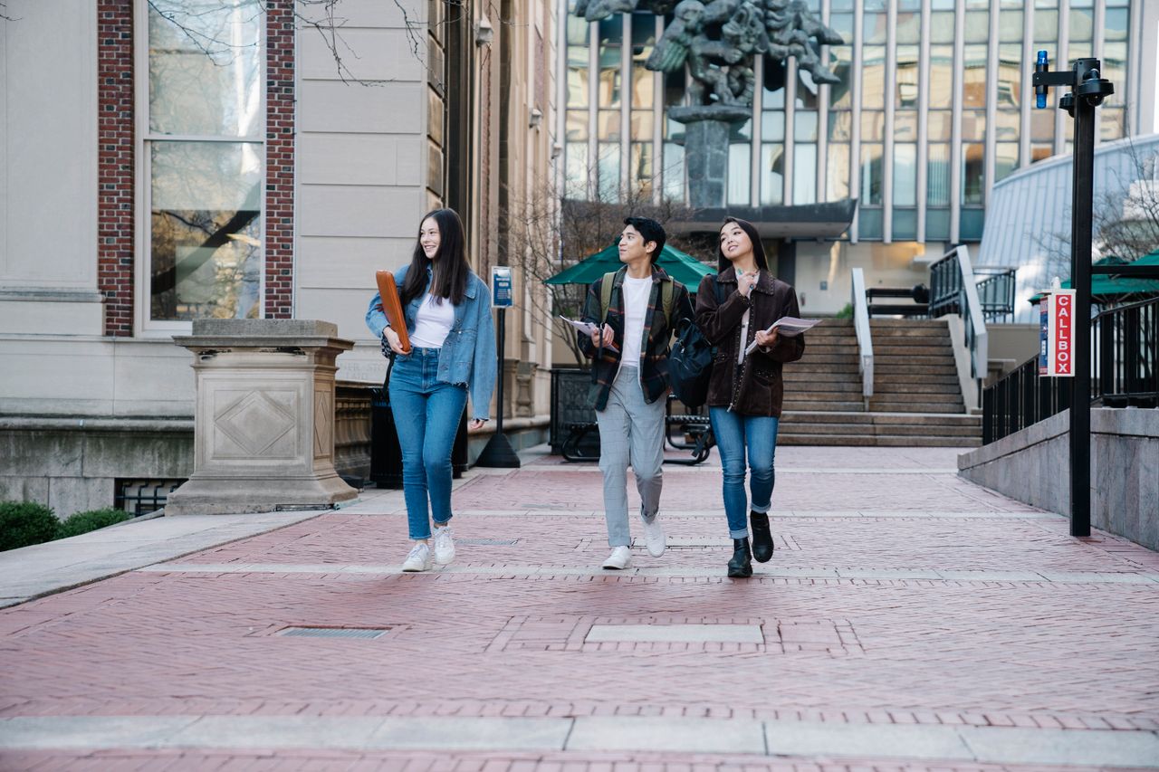 projects-header A diverse group of students walking on campus pavement, cheerful and engaged.
