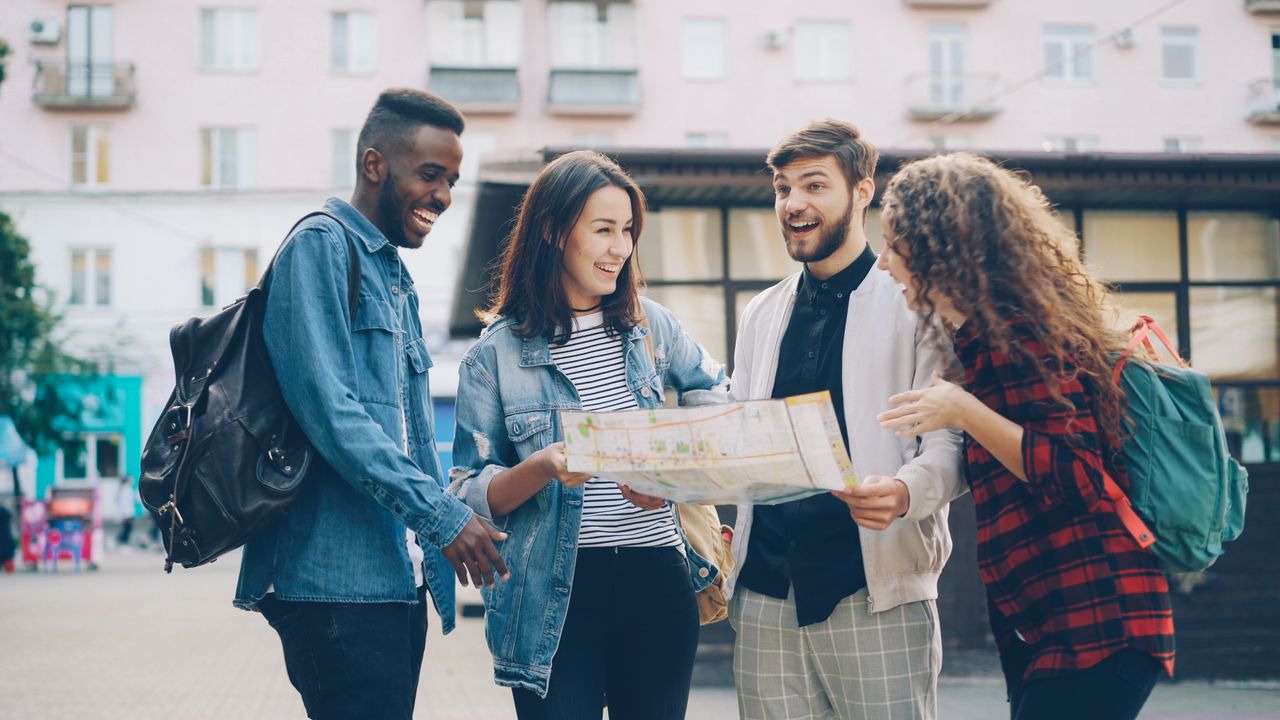 gallery-06 A group of friends happily exploring a city using a map. Perfect for travel and adventure themes.
