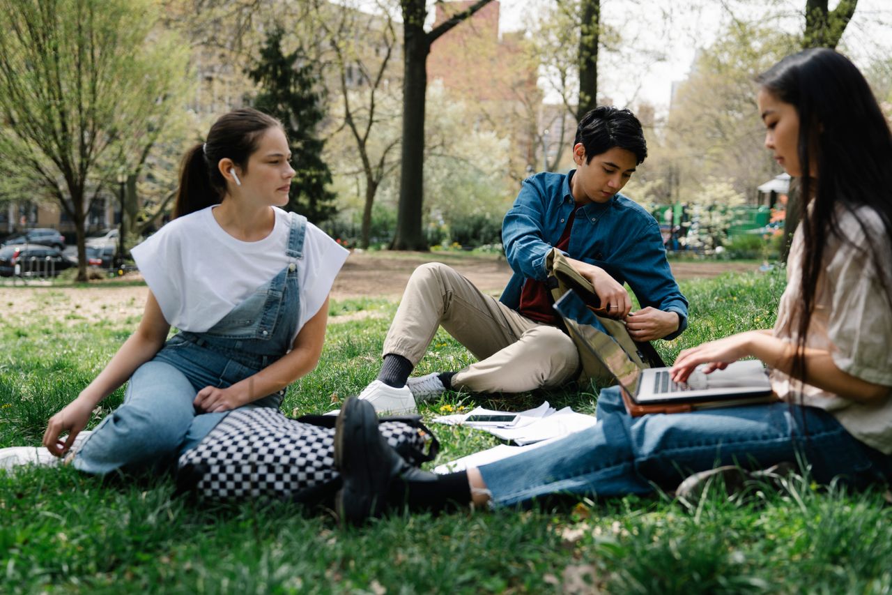 featured-images-01 College students study together in a park, enjoying a sunny day on the grass.
